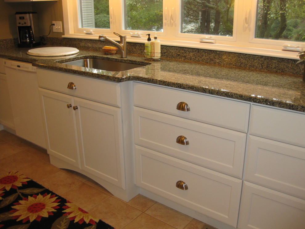 Example of a transitional l-shaped ceramic tile and beige floor kitchen design in Boston with an undermount sink, shaker cabinets, white cabinets, granite countertops, white appliances and green countertops
