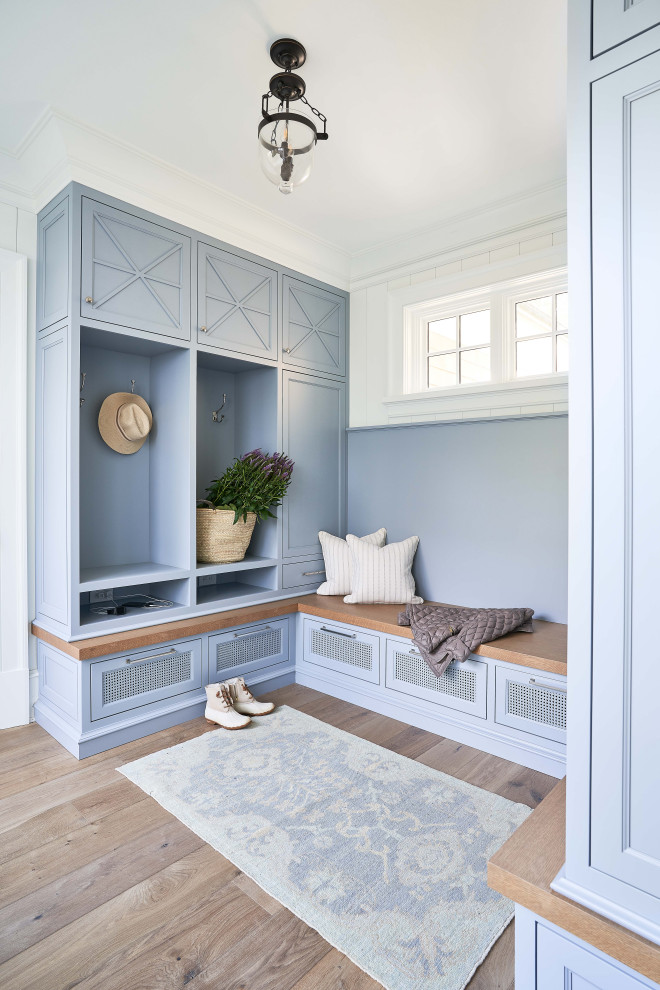 Inspiration for a beach style mudroom in Charlotte with white walls and medium hardwood floors.