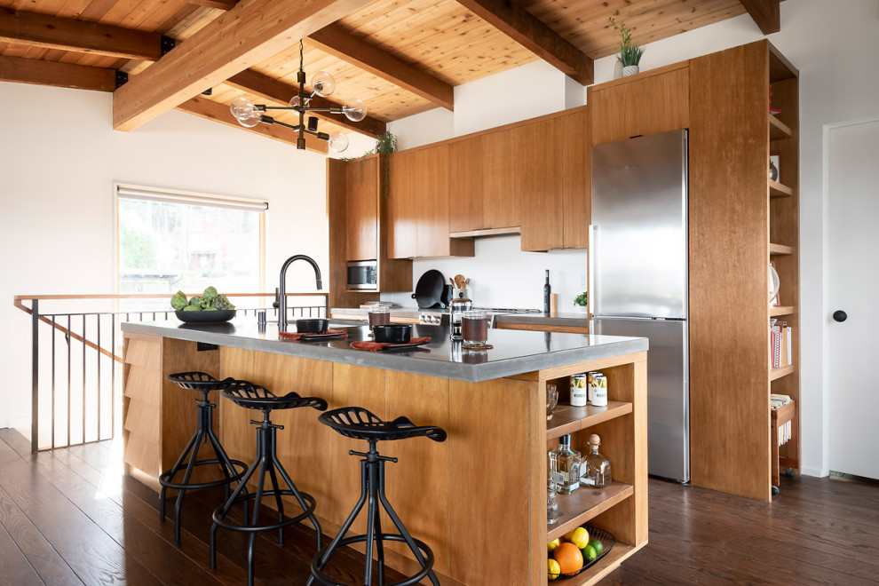 Large contemporary kitchen in Sacramento with a single-bowl sink, medium wood cabinets, concrete benchtops, stainless steel appliances, medium hardwood floors, with island, brown floor, grey benchtop and exposed beam.