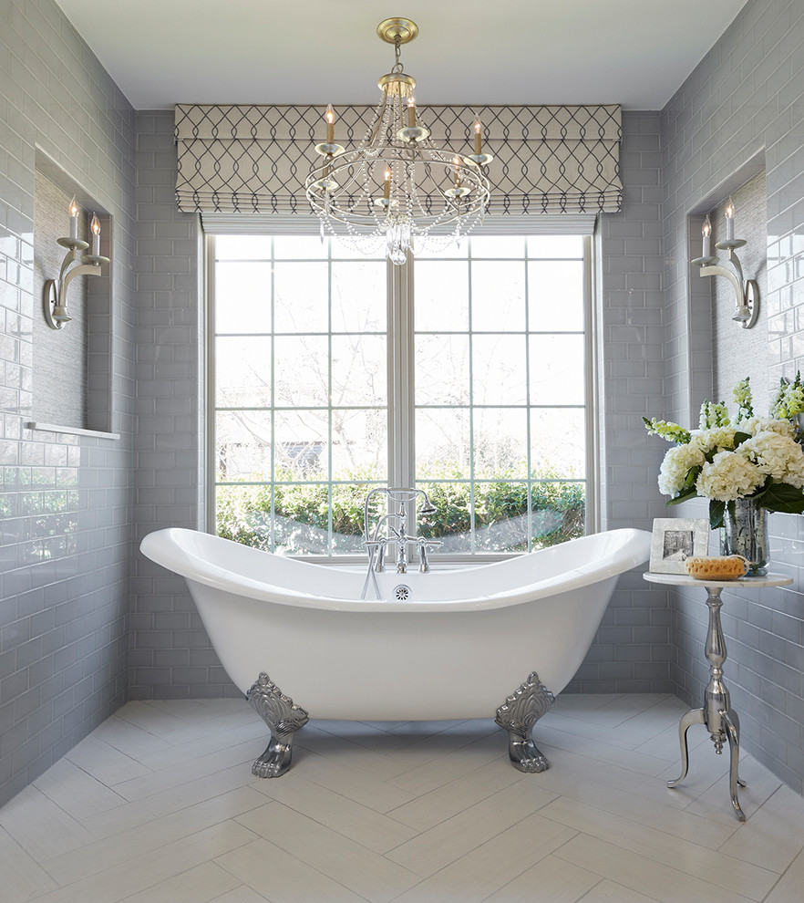 This is an example of a traditional master bathroom in Dallas with a claw-foot tub, gray tile, subway tile, grey walls and white floor.