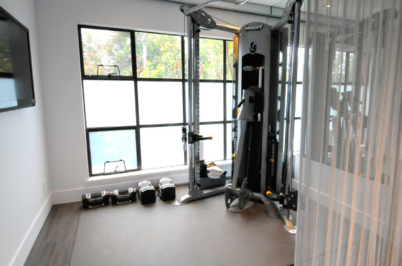 This is an example of a small modern home weight room in Vancouver with white walls.