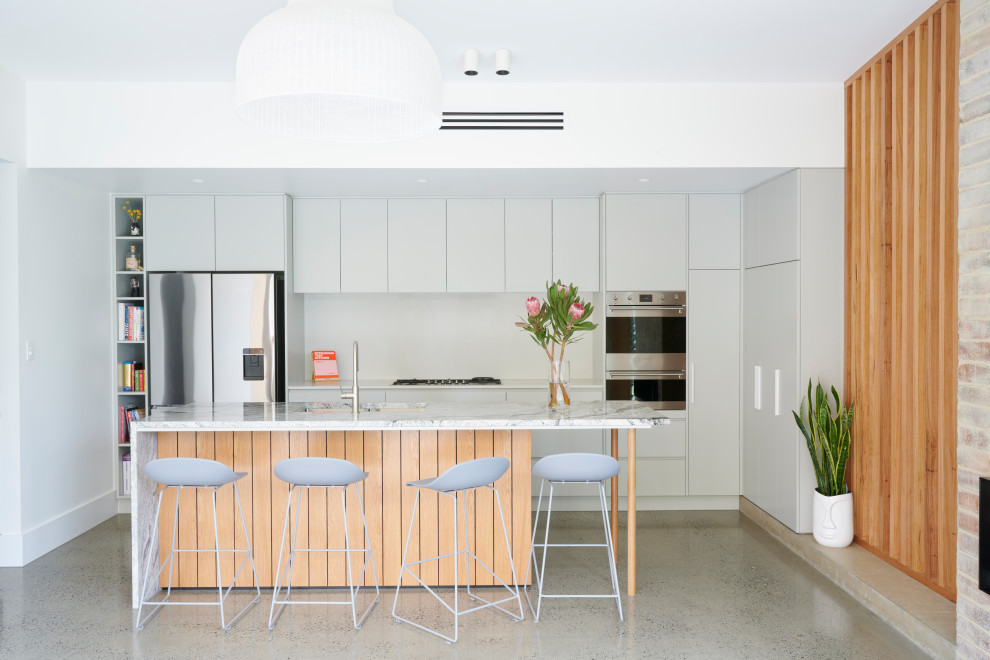 Design ideas for a small contemporary galley eat-in kitchen in Adelaide with a drop-in sink, marble benchtops, white splashback, stone slab splashback, stainless steel appliances, concrete floors, with island, grey floor and grey benchtop.