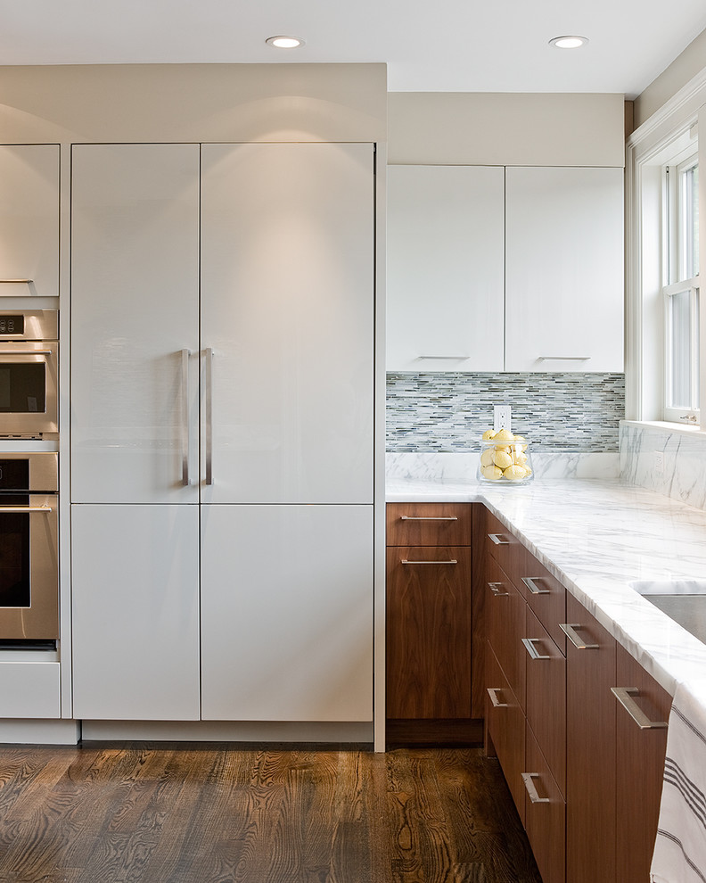 Photo of a contemporary kitchen in Boston with panelled appliances, marble benchtops, flat-panel cabinets, white cabinets, an undermount sink, matchstick tile splashback and grey splashback.
