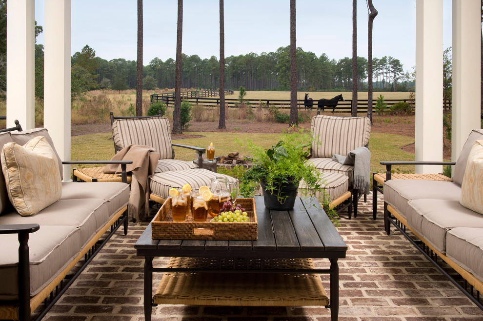 Design ideas for a traditional backyard patio in Atlanta with brick pavers and a roof extension.