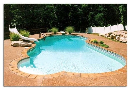 Backyard stone and custom-shaped pool photo