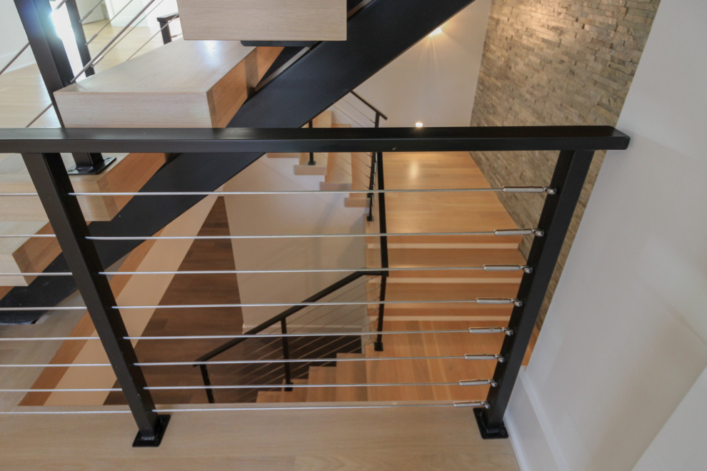 Example of a large eclectic wooden floating metal railing and brick wall staircase design in DC Metro