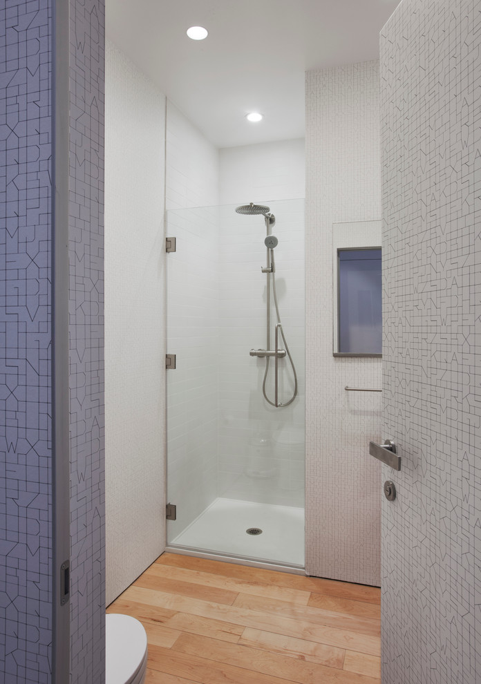 Design ideas for a contemporary bathroom in New York with an alcove shower and light hardwood floors.