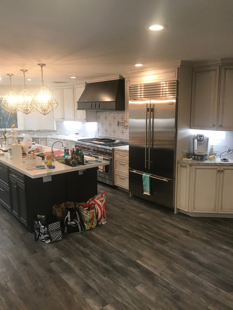 Photo of a large mediterranean u-shaped eat-in kitchen in San Francisco with an undermount sink, flat-panel cabinets, white cabinets, quartzite benchtops, white splashback, porcelain splashback, stainless steel appliances, with island and grey benchtop.