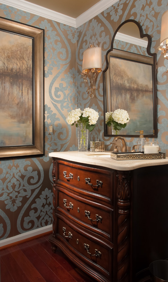 Traditional powder room in Baltimore with an undermount sink, furniture-like cabinets, dark wood cabinets, multi-coloured walls, dark hardwood floors and beige benchtops.
