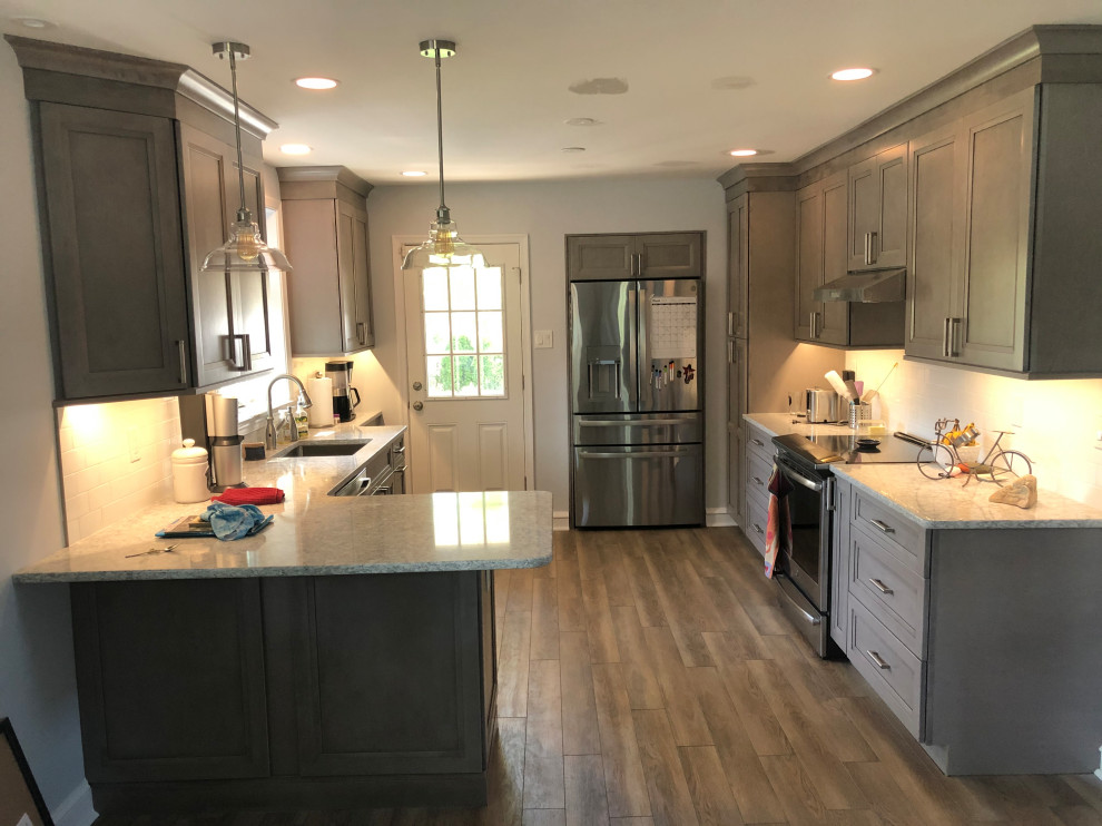 Expansive transitional u-shaped eat-in kitchen in Philadelphia with an undermount sink, shaker cabinets, yellow cabinets, quartzite benchtops, white splashback, porcelain splashback, stainless steel appliances, vinyl floors, a peninsula, grey floor and yellow benchtop.