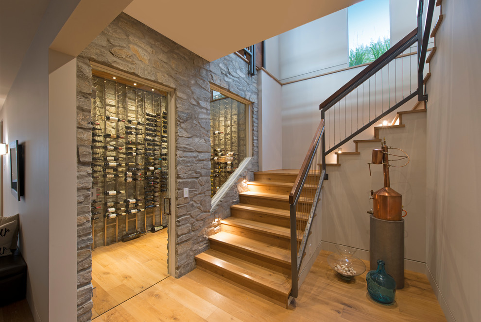 This is an example of a contemporary wine cellar in Vancouver with medium hardwood floors and display racks.