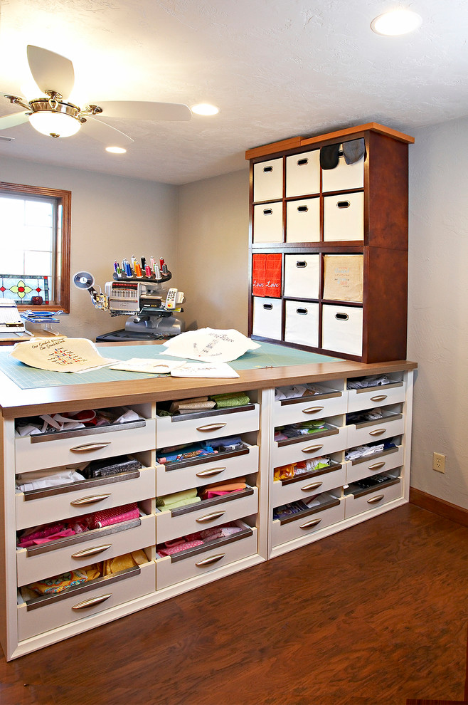 Photo of a large country craft room in St Louis with beige walls, medium hardwood floors and a built-in desk.