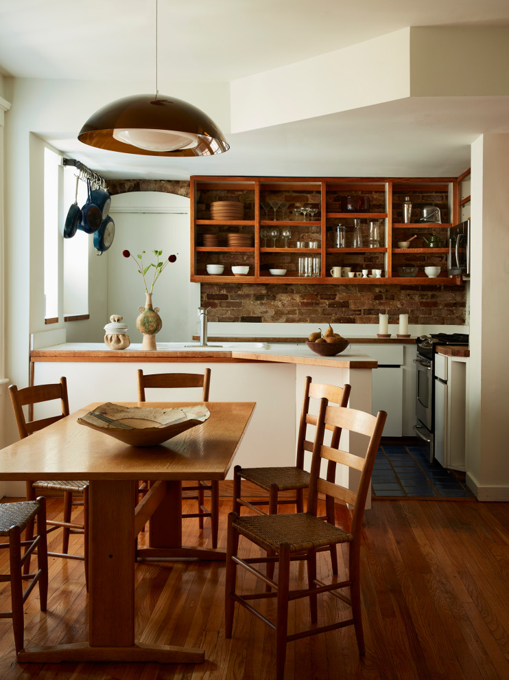 Photo of a small midcentury kitchen/dining combo in Boston with white walls and light hardwood floors.