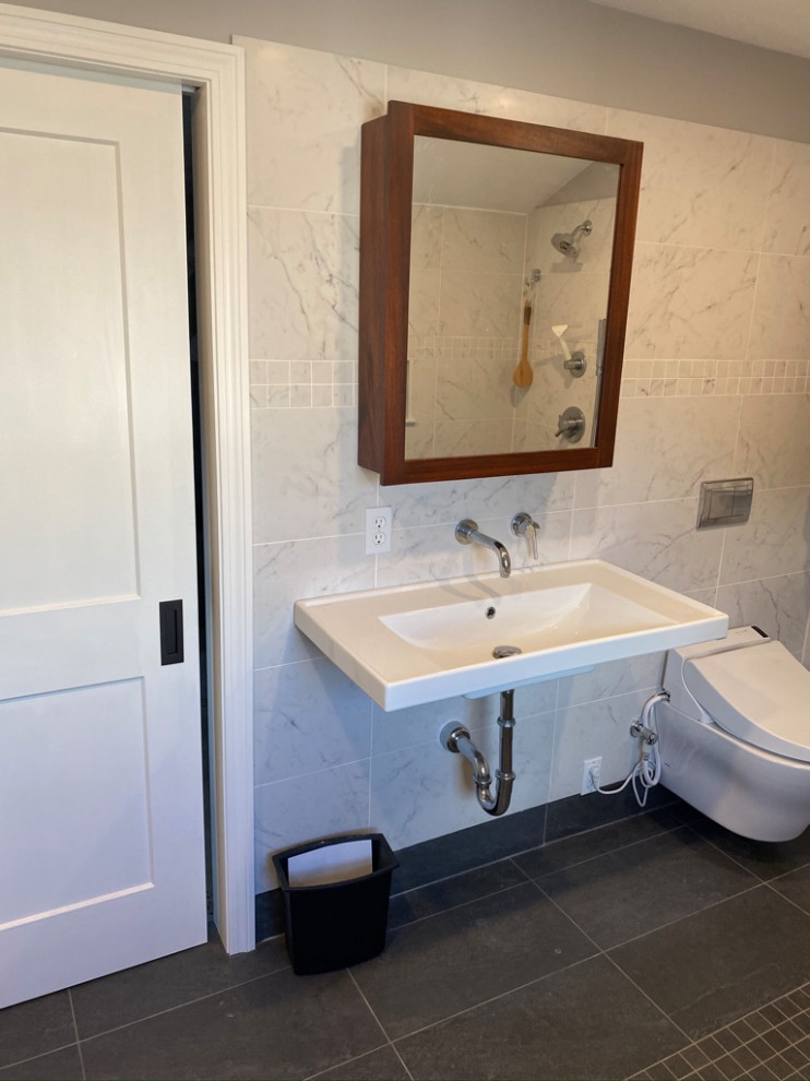 Small contemporary master bathroom in Boston with a curbless shower, a wall-mount toilet, white tile, porcelain tile, grey walls, porcelain floors, a wall-mount sink, grey floor, an open shower, a niche, a single vanity and a floating vanity.