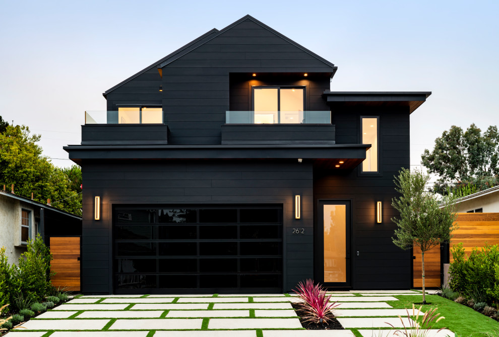Aménagement d'une grande façade de maison noire contemporaine en bois et bardage à clin à un étage avec un toit en appentis, un toit en métal et un toit noir.