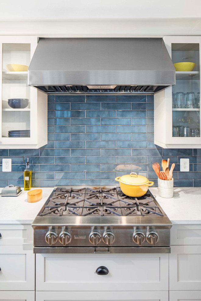 Trendy l-shaped medium tone wood floor and brown floor open concept kitchen photo in DC Metro with an undermount sink, shaker cabinets, white cabinets, quartzite countertops, blue backsplash, ceramic backsplash, stainless steel appliances, an island and white countertops
