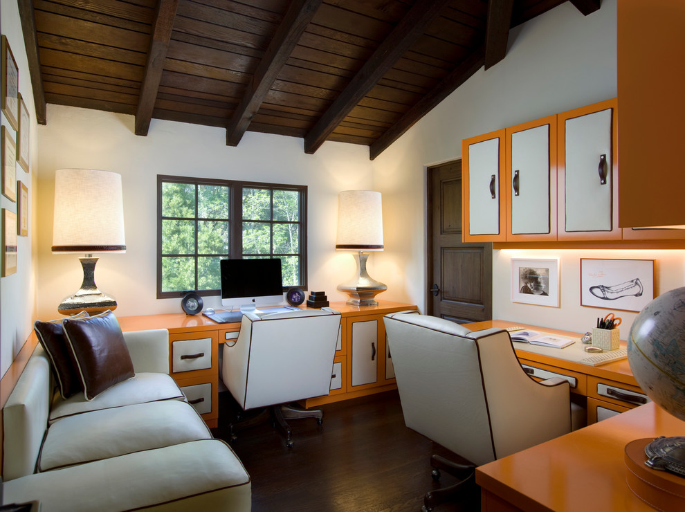Mid-sized transitional home office in Santa Barbara with white walls, dark hardwood floors and a built-in desk.