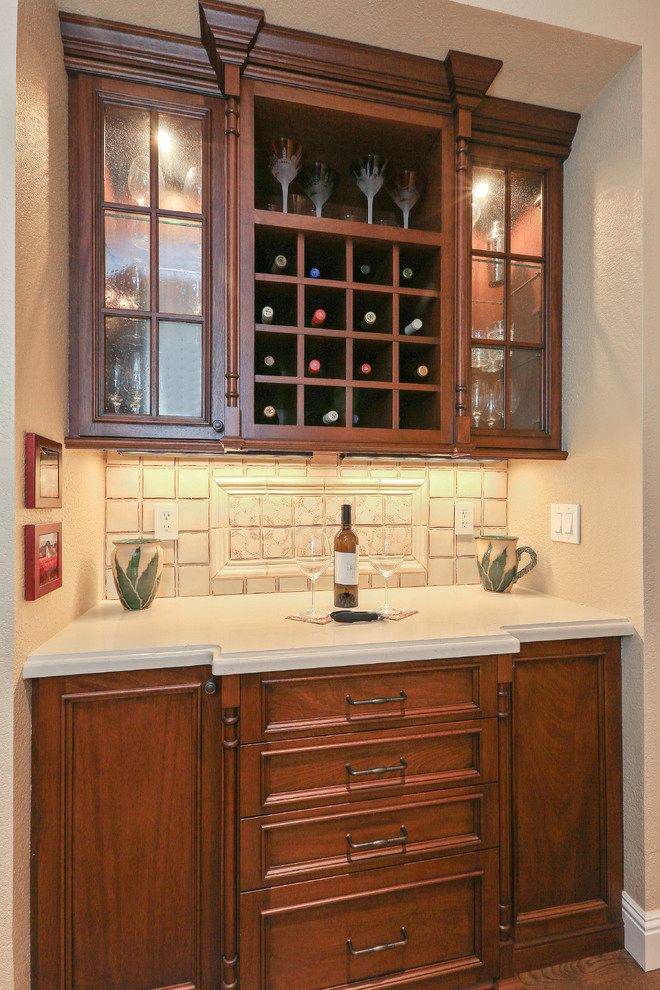 This is an example of a small traditional single-wall wet bar in San Francisco with dark wood cabinets, beige splashback, ceramic splashback, recessed-panel cabinets and quartz benchtops.