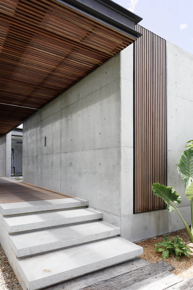 Inspiration for a mid-sized modern two-storey concrete grey house exterior in Central Coast with a flat roof and a metal roof.