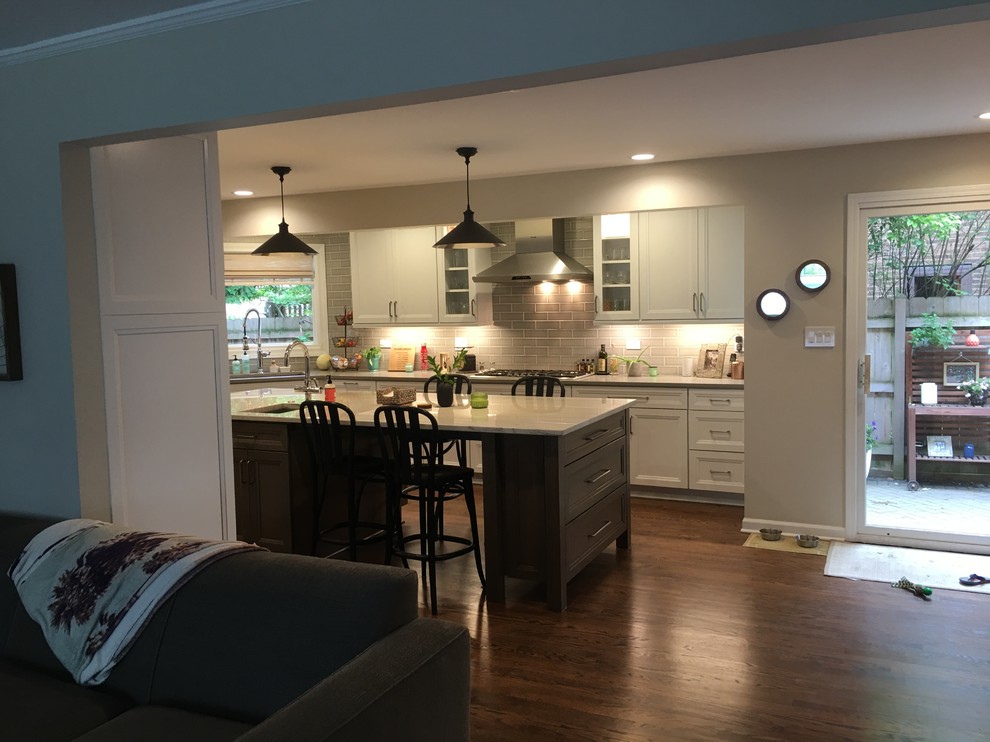 Large transitional u-shaped dark wood floor and brown floor open concept kitchen photo in Chicago with an undermount sink, flat-panel cabinets, white cabinets, quartz countertops, gray backsplash, ceramic backsplash, stainless steel appliances, an island and gray countertops