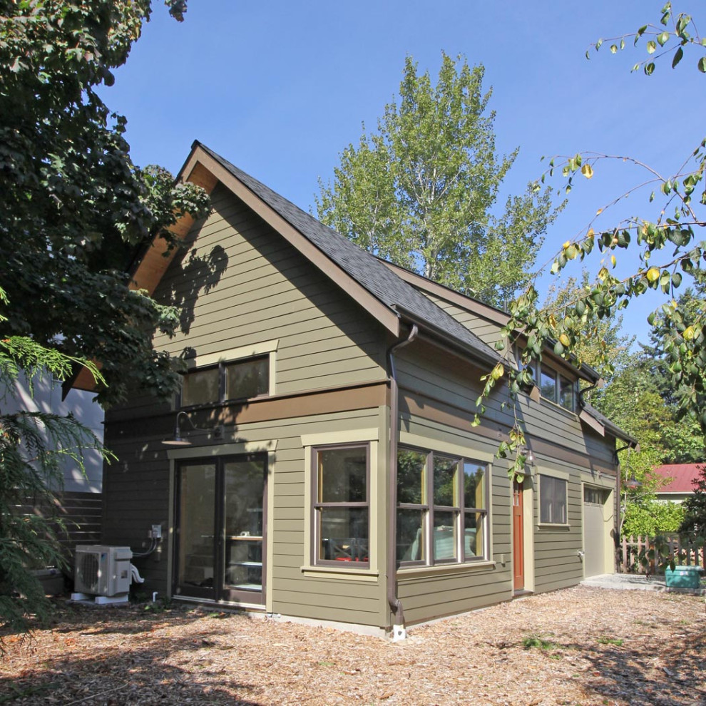 This is an example of a small two-storey green house exterior in Seattle with concrete fiberboard siding, a gable roof and a shingle roof.