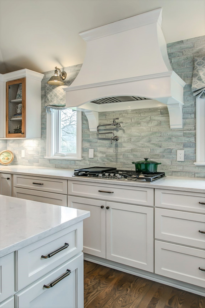 ナッシュビルにある高級な広いシャビーシック調のおしゃれなキッチン (シェーカースタイル扉のキャビネット、白いキャビネット、青いキッチンパネル、無垢フローリング、茶色い床、白いキッチンカウンター) の写真
