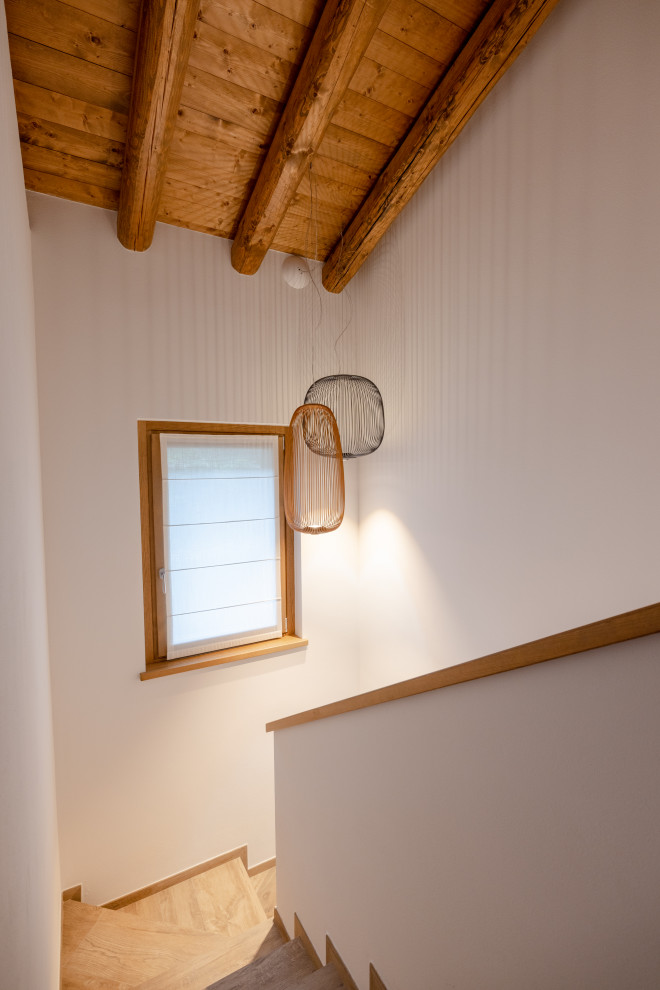 Inspiration för en mellanstor minimalistisk u-trappa i målat trä, med sättsteg i målat trä och räcke i flera material