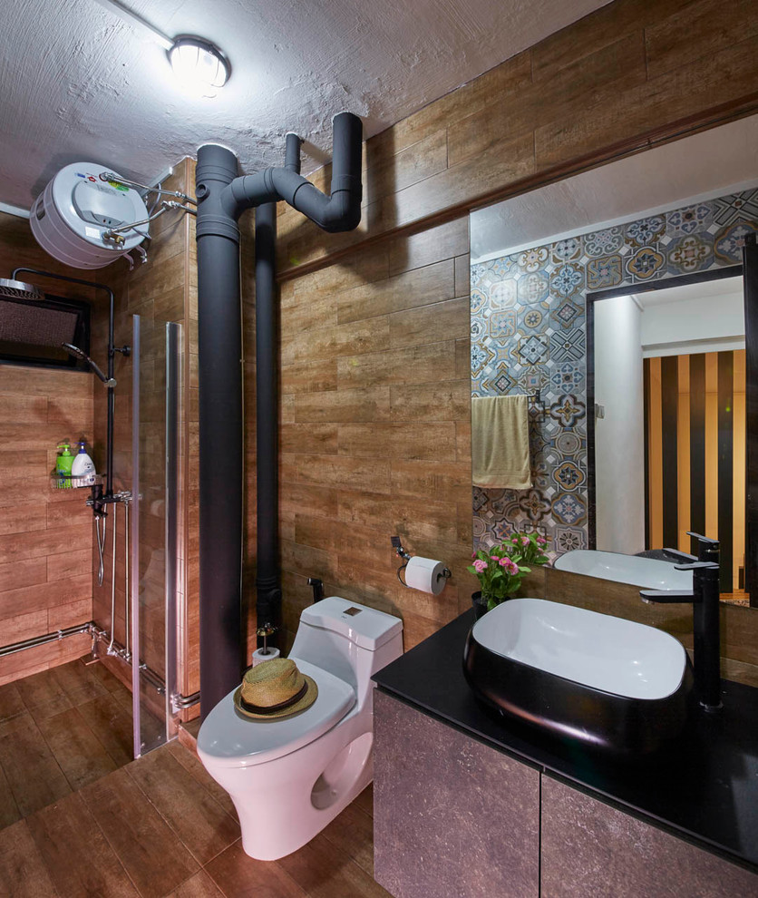 This is an example of a mid-sized industrial 3/4 bathroom in Singapore with flat-panel cabinets, an open shower, a one-piece toilet, brown tile, solid surface benchtops and an open shower.