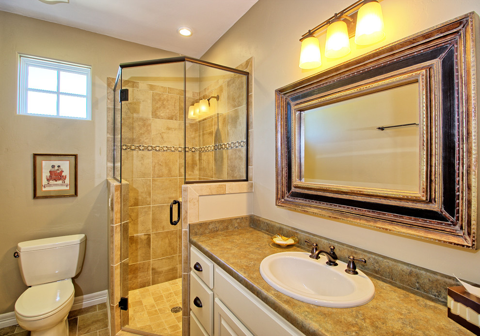 Design ideas for a mid-sized master bathroom in Denver with raised-panel cabinets, white cabinets, a corner shower, a two-piece toilet, beige tile, ceramic tile, beige walls, ceramic floors, a drop-in sink and laminate benchtops.