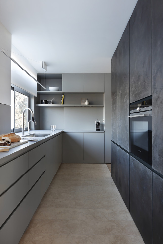 This is an example of a mid-sized contemporary l-shaped kitchen in London with an undermount sink, flat-panel cabinets, grey cabinets and no island.