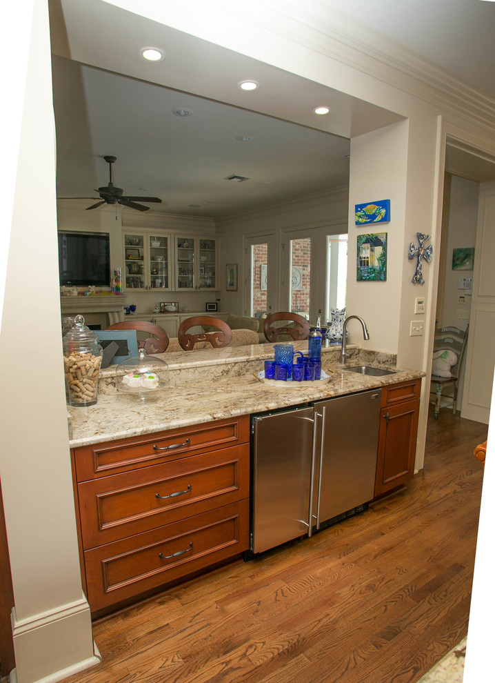 Inspiration for a large traditional u-shaped kitchen in New Orleans with an undermount sink, recessed-panel cabinets, medium wood cabinets, stainless steel appliances and medium hardwood floors.