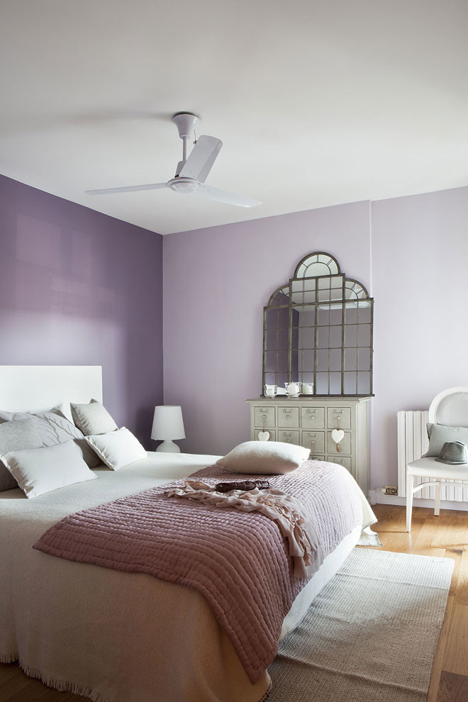This is an example of a mid-sized transitional master bedroom in Barcelona with purple walls, light hardwood floors and no fireplace.