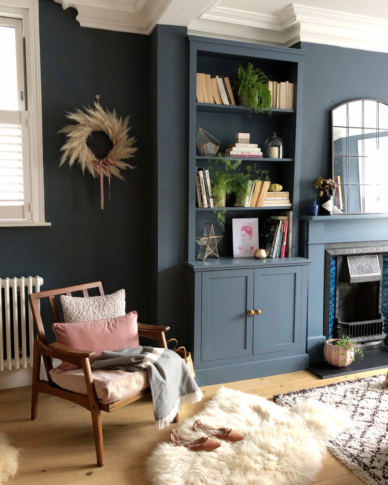Exemple d'un salon chic de taille moyenne et ouvert avec une salle de réception, un mur bleu, parquet clair, une cheminée standard, un manteau de cheminée en carrelage et du lambris.