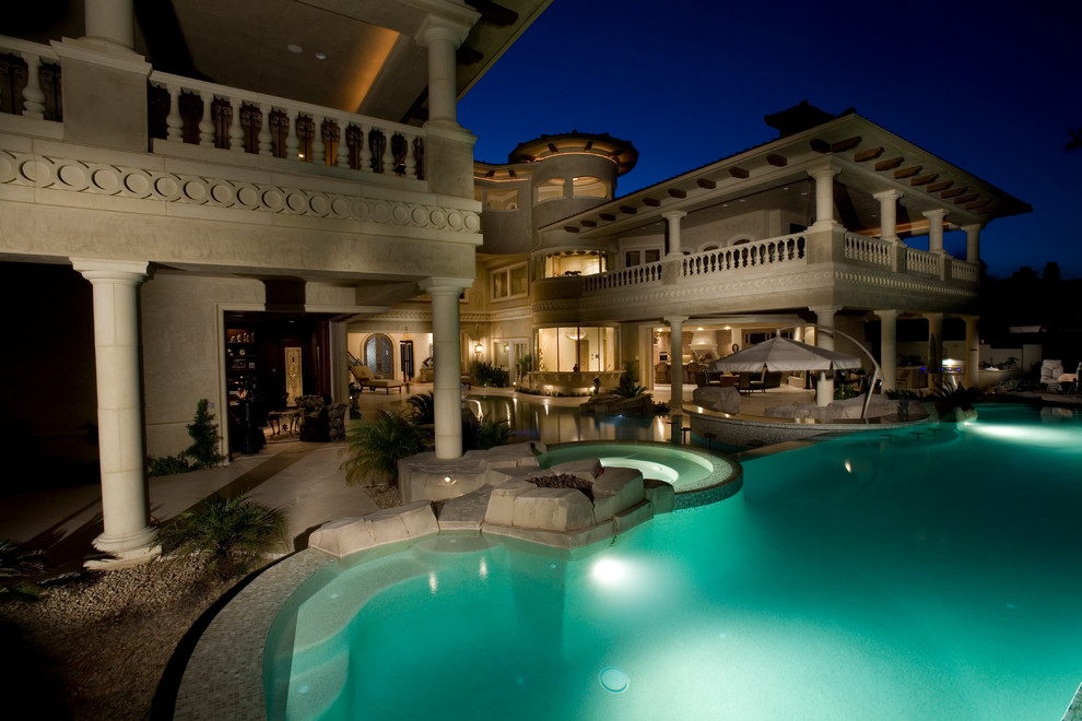 Photo of an expansive traditional backyard custom-shaped pool in Las Vegas with a hot tub.