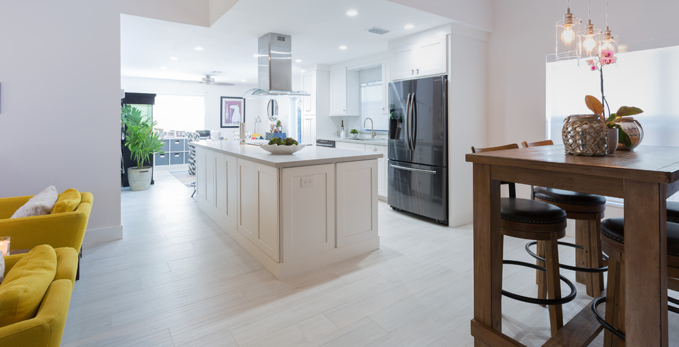 Open concept kitchen - small transitional single-wall porcelain tile open concept kitchen idea in Miami with an undermount sink, shaker cabinets, white cabinets, quartz countertops, white backsplash and an island