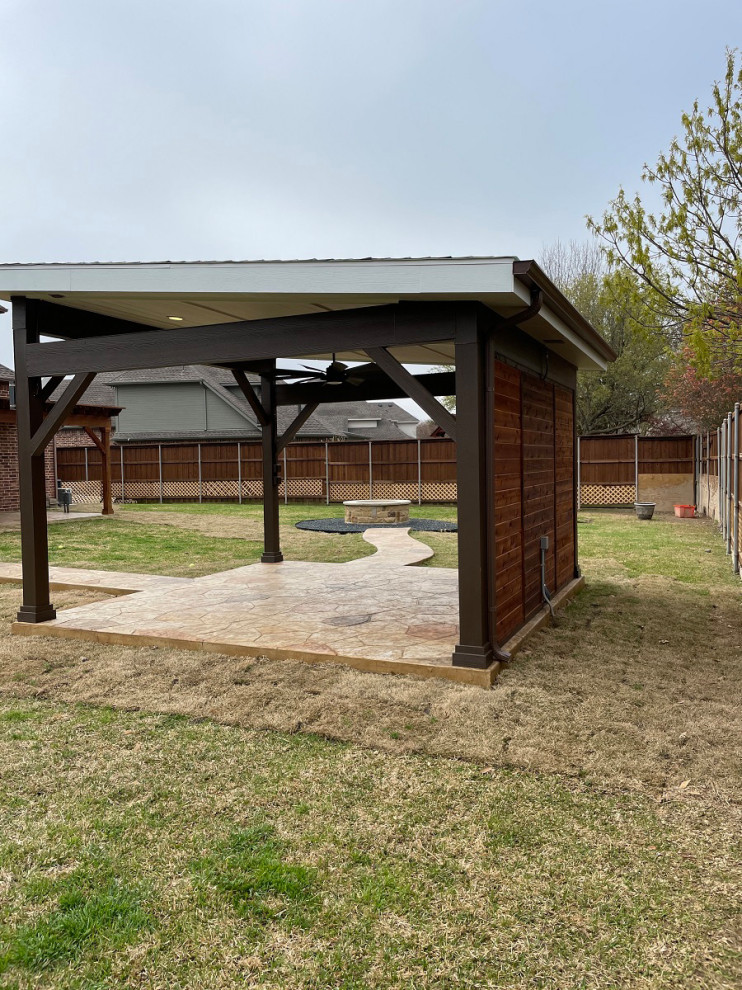 Modelo de patio rural extra grande en patio trasero con brasero, suelo de hormigón estampado y cenador