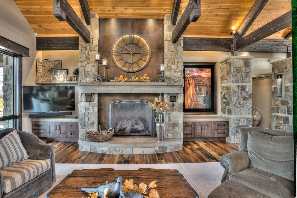 This is an example of an expansive country open concept living room in Denver with a home bar, beige walls, medium hardwood floors, a standard fireplace, a stone fireplace surround and no tv.