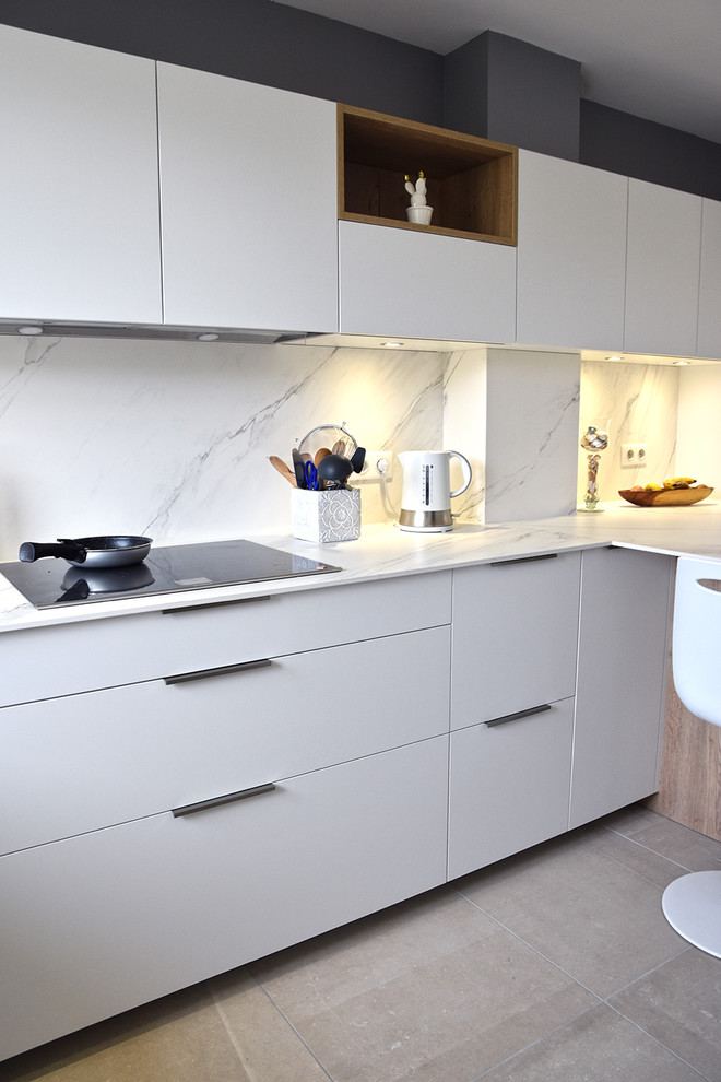 This is an example of a mid-sized modern u-shaped separate kitchen in Lyon with an integrated sink, beaded inset cabinets, white cabinets, tile benchtops, white splashback, ceramic splashback, stainless steel appliances, ceramic floors and grey floor.