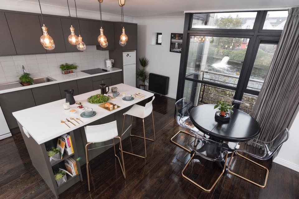 Photo of a mid-sized contemporary single-wall open plan kitchen in Other with a double-bowl sink, flat-panel cabinets, grey cabinets, laminate benchtops, white splashback, ceramic splashback, white appliances, dark hardwood floors, with island and brown floor.