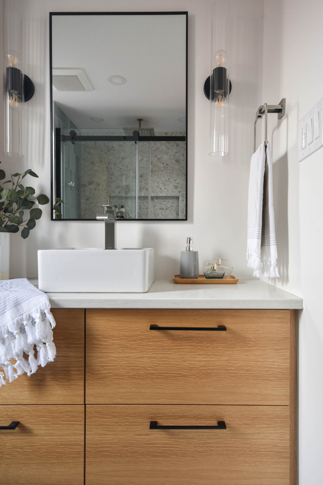 Idée de décoration pour une petite salle de bain principale design en bois brun avec un placard à porte plane, une douche à l'italienne, un bidet, un carrelage gris, des carreaux de porcelaine, un mur blanc, un sol en carrelage de porcelaine, une vasque, un plan de toilette en surface solide, un sol gris, une cabine de douche à porte battante, un plan de toilette blanc, une niche, meuble simple vasque et meuble-lavabo suspendu.