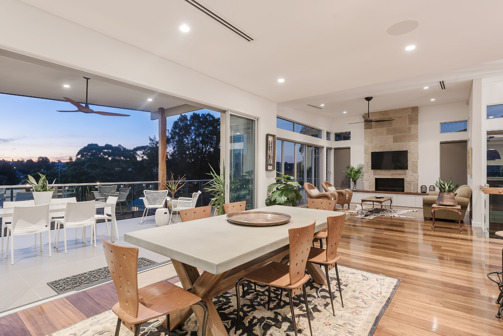 This is an example of a contemporary open plan dining in Sydney with white walls, medium hardwood floors and beige floor.