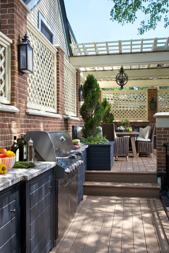 This is an example of an expansive traditional backyard deck in Chicago with a pergola.