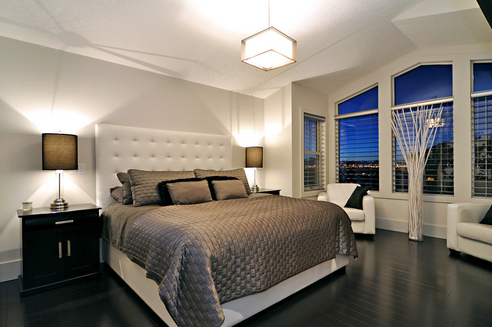Contemporary bedroom in Calgary with white walls and black floor.
