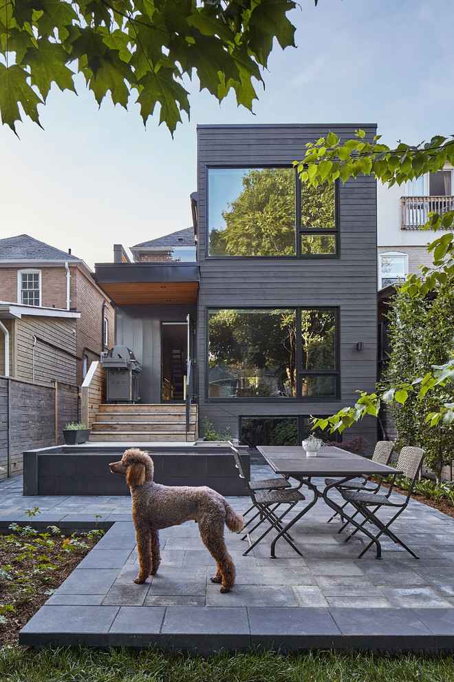 Design ideas for a scandinavian three-storey black exterior in Toronto with a flat roof.