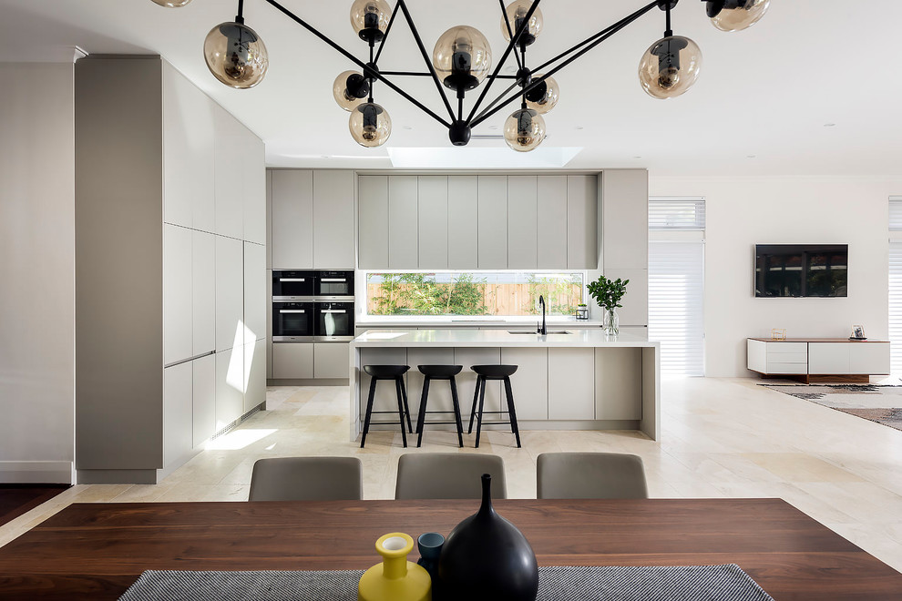 Inspiration for a large contemporary galley open plan kitchen in Perth with an undermount sink, grey cabinets, quartz benchtops, window splashback, stainless steel appliances, travertine floors, with island and beige floor.