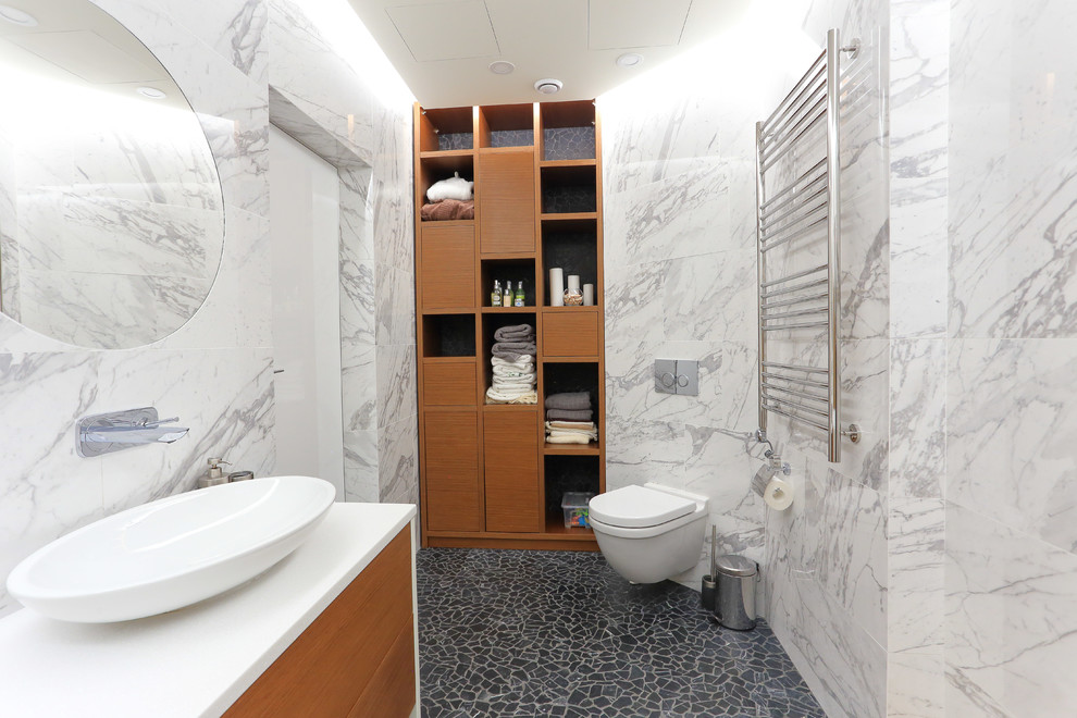Photo of a contemporary bathroom in Moscow with a wall-mount toilet, porcelain tile, porcelain floors, solid surface benchtops and a vessel sink.