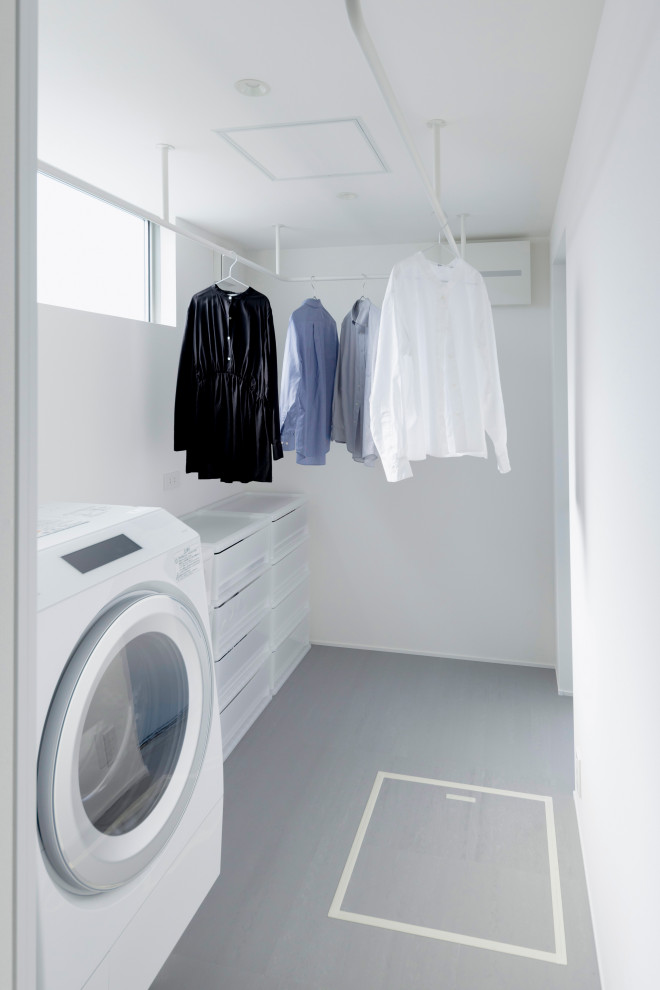 Mid-sized scandinavian laundry room in Other with white walls, concrete floors, grey floor, vaulted and wallpaper.