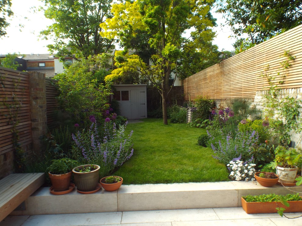 Photo of a contemporary backyard partial sun garden in London.
