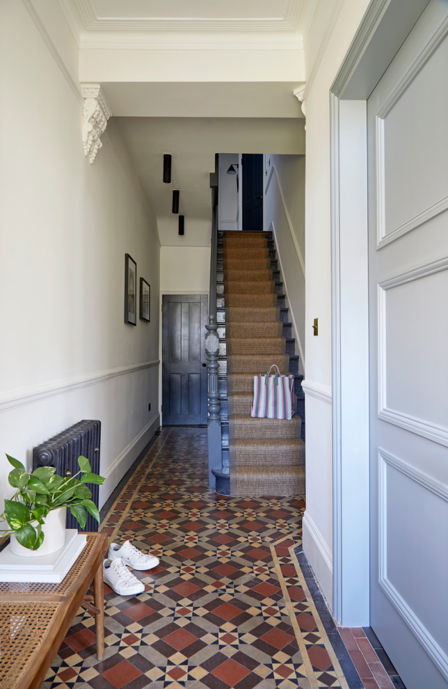 Inspiration for a mid-sized modern ceramic tile and brown floor hallway remodel in London with beige walls