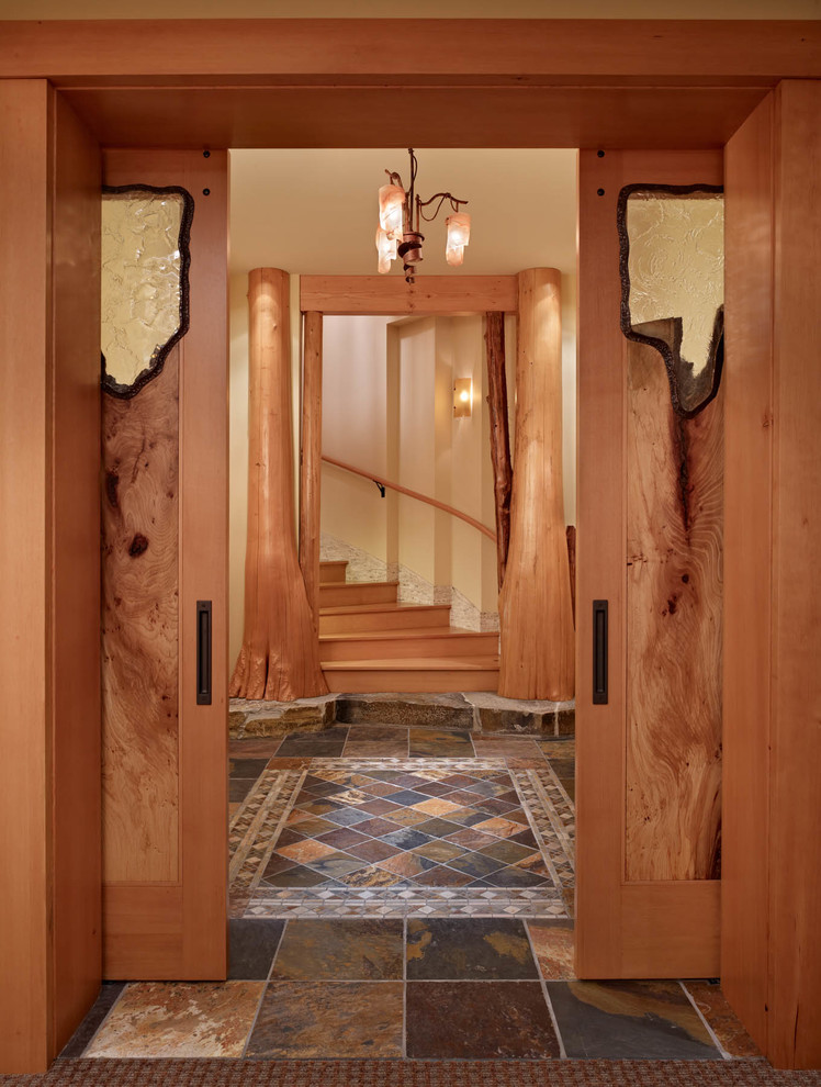 This is an example of an expansive country hallway in Seattle with beige walls and slate floors.